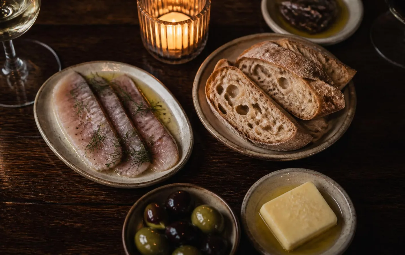 Small plates by candlelight: cured fish, sourdough, olives and butter.